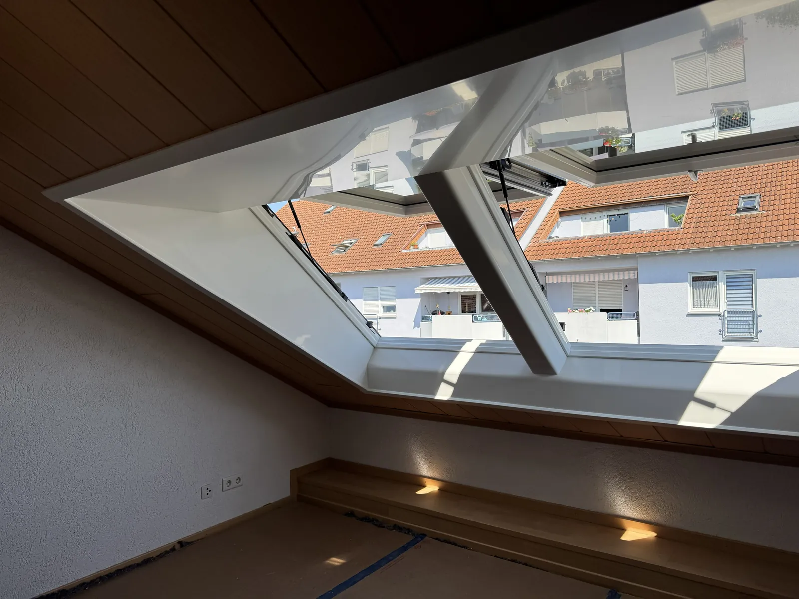 Fensterkombination nach einem Kombi-Einbau, von innen gesehen: große Glasflächen mit Blick über die Nachbarhäuser